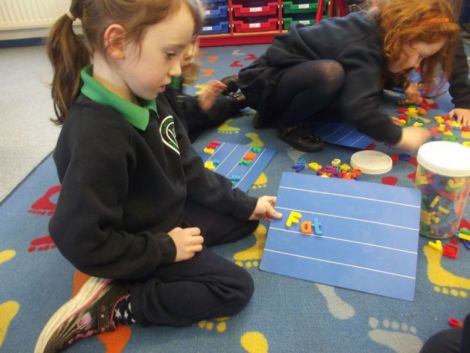 Using magnetic letters to make cvc words.